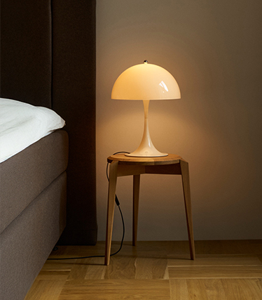 Lampada da comodino a forma di fungo che diffonde una luce morbida in una camera accogliente