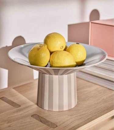 Ciotola OY OY Living con limoni su un elegante tavolo in legno dai delicati toni pastello.