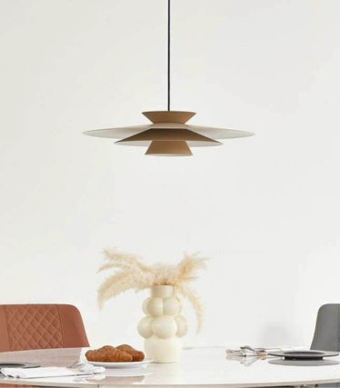 Lampada a sospensione moderna sopra il tavolo da pranzo con toni naturali caldi e design senza tempo.